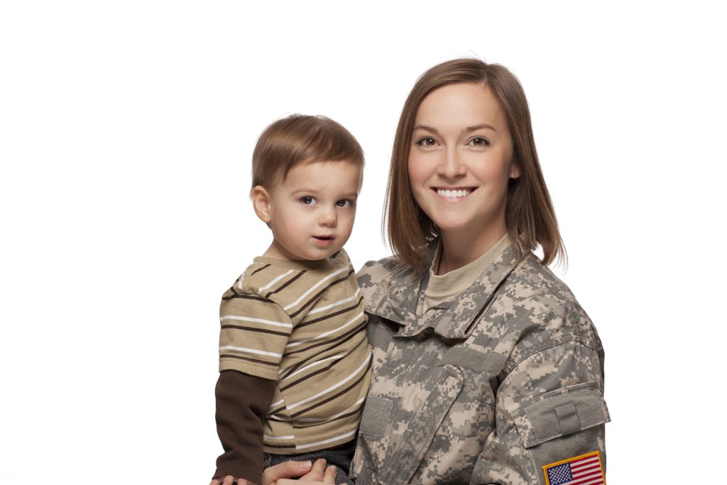 Smiling woman solider holding a child